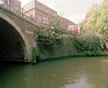 822594 Gezicht op de Bijlhouwerbrug (links) en de kademuur aan de Oudegracht te Utrecht; op de achtergrond het ...